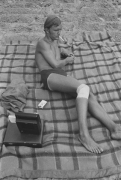 Man with injured knee at the beach smoking, Detroit, 1968